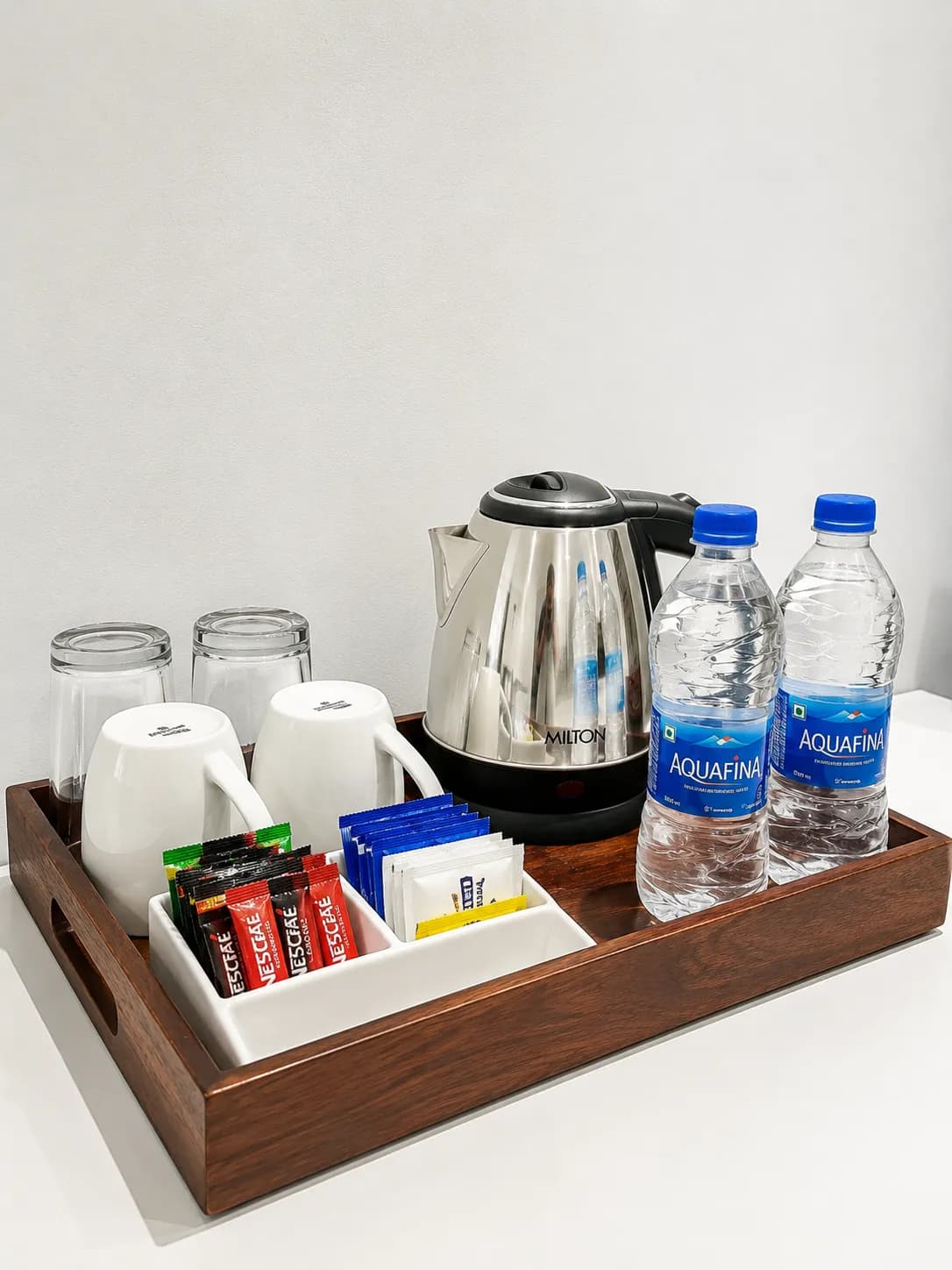 The in-room tea and coffee tray, kettle and cups on dark wood