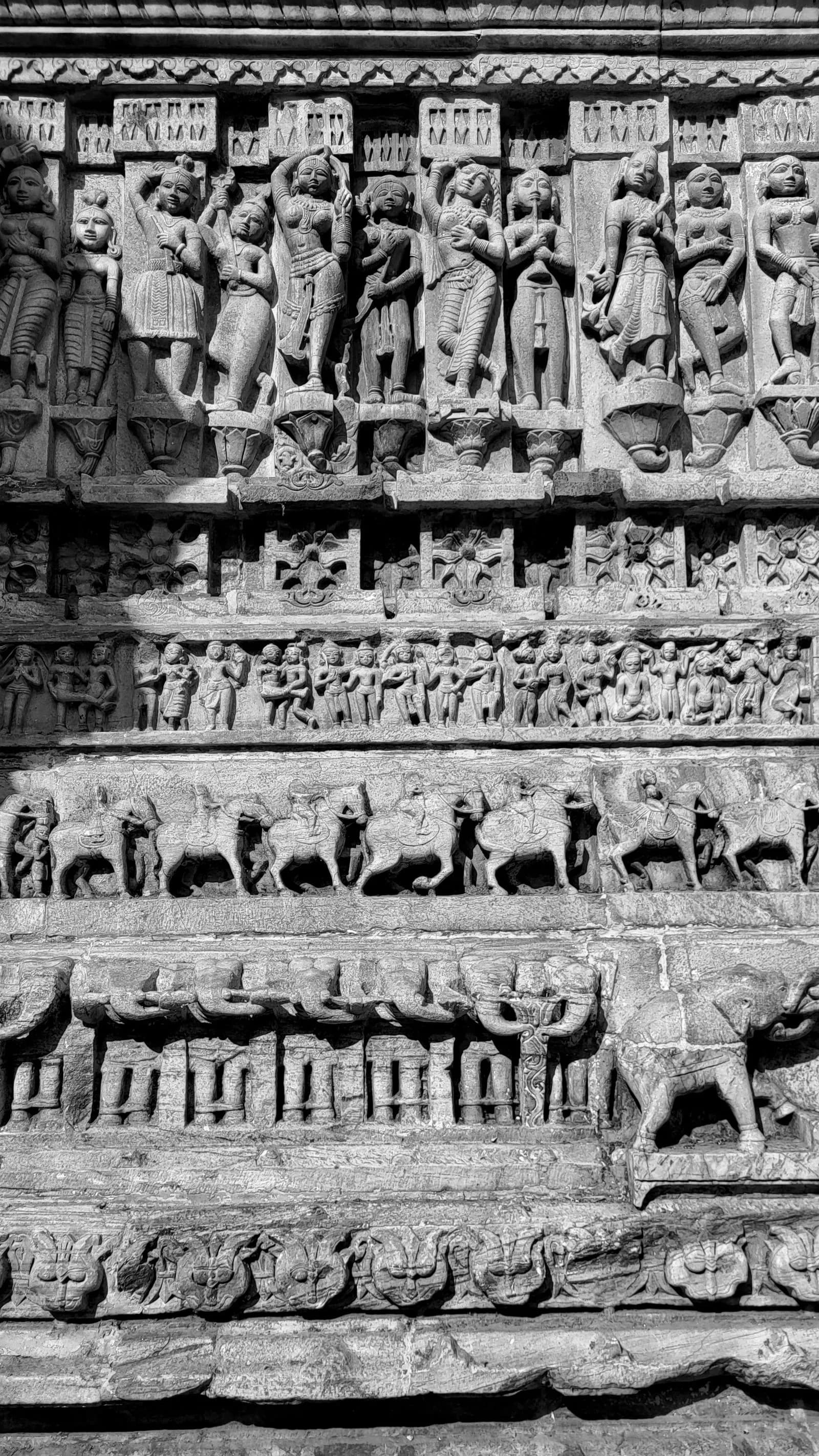 Carved stone friezes of dancers, musicians, horsemen and elephants on the Jagdish Temple walls