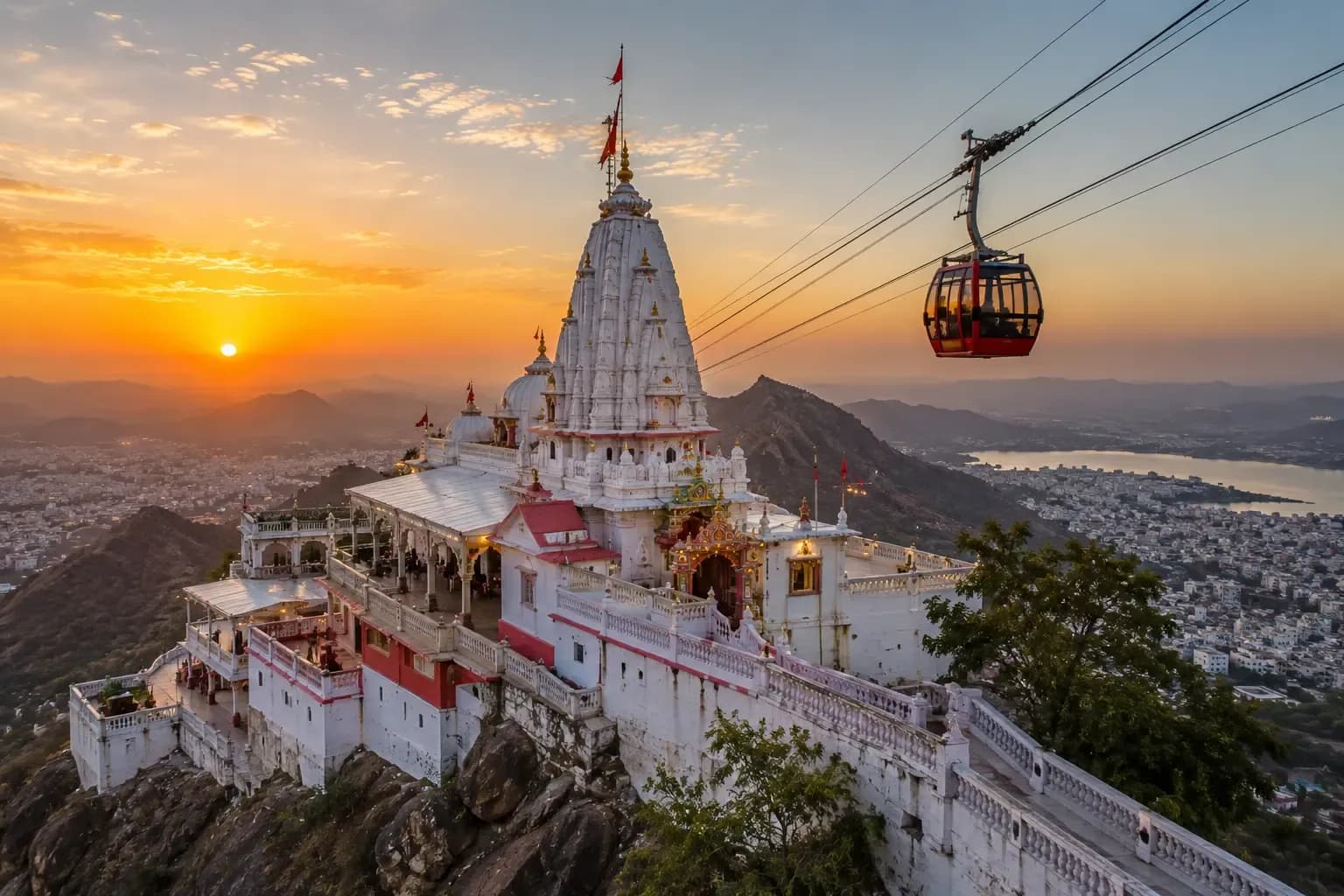The Karni Mata hilltop temple and ropeway above Udaipur, the city and lake below at sunset