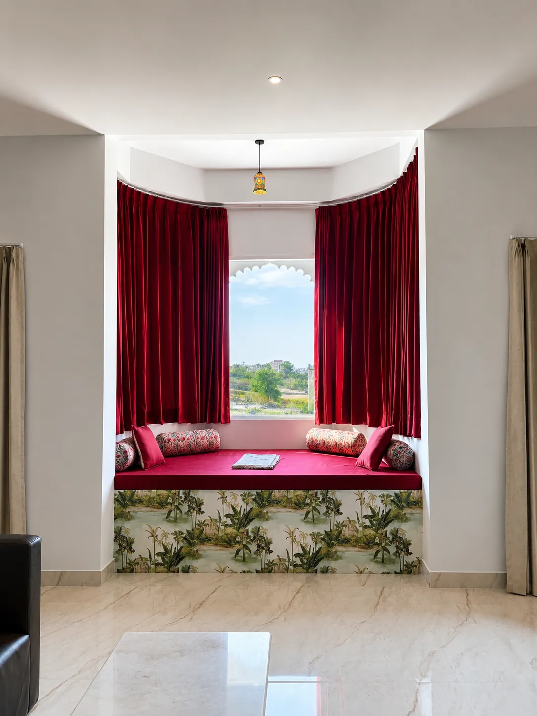 Traditional jharokha window seat with red velvet drapes and bolsters